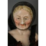 A rare late 19th century youth and old age double faced ceramic doll head, circa 1870, with a