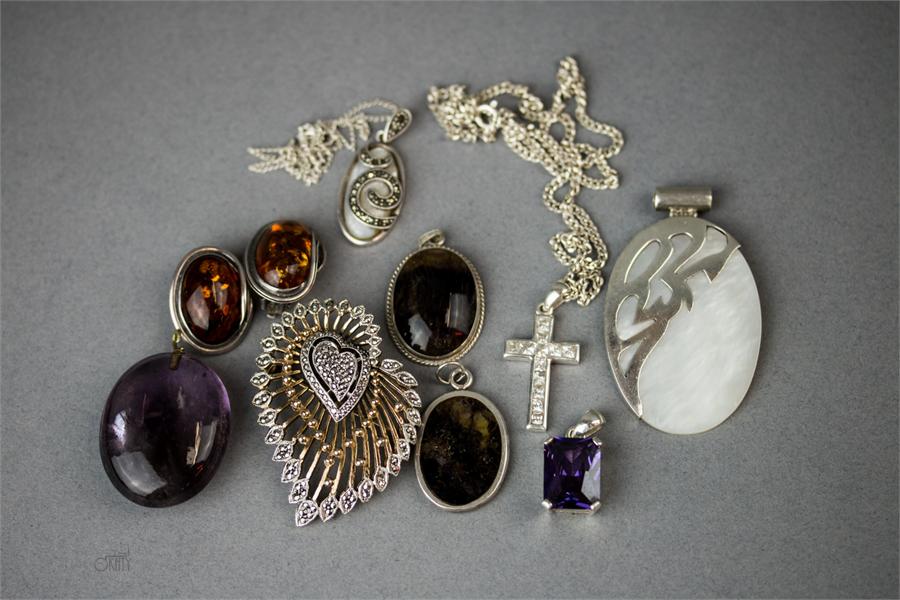 A group of silver pendants including a Blue John oval slice, mother of pearl oval, two amber