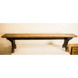 An antique pine long bench with shaped ends.