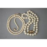 A cultured pearl necklace with a 9ct gold and ruby clasp, and another with graduated simulated