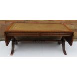 A mahogany sofa table with brown tooled leather to
