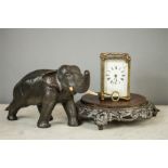 A 19th century brass carriage clock with key, together with a cast metal painted elephant, and a