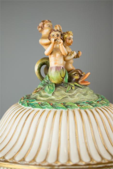 An Italian Capodimonte urn and cover profusely decorated with relief modelled cherubs, chariots, - Image 2 of 3