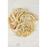 A quantity of antique carved bone beaded necklaces and loose beads.