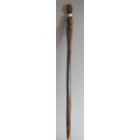 A carved African tribal art walking stick, carved to the top with a female figure holding a water