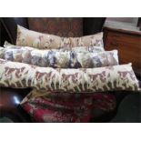 A group of four long baluster cushions, tapestry covers depicting dogs, kittens, huntsmen and