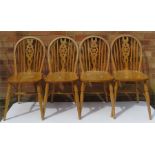 A set of four wheel back pine kitchen chairs.