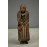 A Welsh 19th century treen character nutcracker in the form of an old lady wearing red bonnet,
