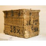 A large Victorian wicker laundry basket with leather straps.