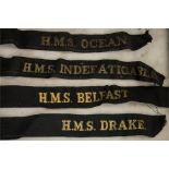 A group of Navy ribbons embroidered in gold thread; HMS Indefatigable, HMS Ocean, HMS Belfast, HMS