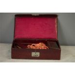 A jewellery box in red leather, containing a quantity of jewellery including a coral pendant,