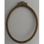 A carved oval giltwood frame with ribbon carved su