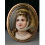 A brooch with a miniature portrait of a young woman, oil on porcelain, numbered 1 verso, in a gold