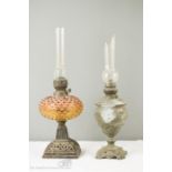 Two brass paraffin lamps,one with an amber coloured glass shade.