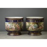 A pair of Sevres style cache pots, both depicting cherubic scenes within cobalt blue upper and lower