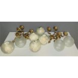 Four cast brass double wall lights with globe form opaque glass shades.