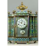 A French Champleve enamel mantle clock, the urn finial surmount above four enamelled columns,