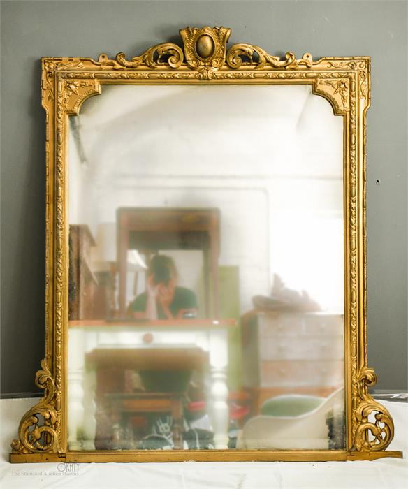 A 19th century giltwood overmantle mirror, with carved crested top, and scroll brackets to the lower