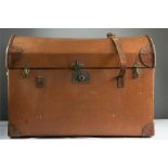 A tan leather motoring dome top trunk.