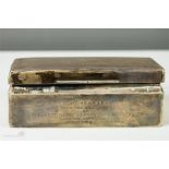 A silver cigarette box, Birmingham 1932, machine engraved with a crest to the top and a presentation