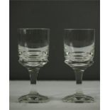 A pair of Moser drinking glasses, with faceted stems and bases.