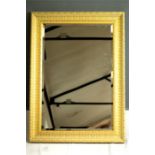 A modern gilded wall mirror of rectangular form.