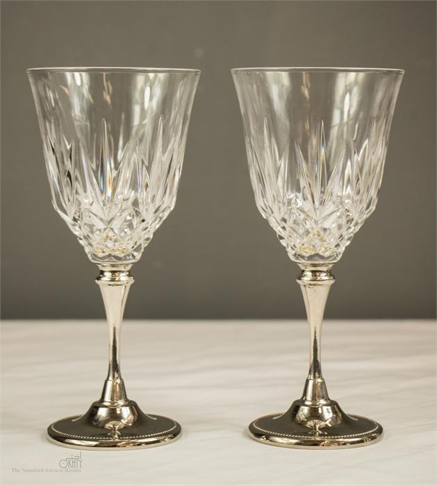 A pair of silver plated stem wine glasses.