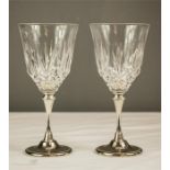 A pair of silver plated stem wine glasses.