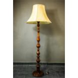 A mahogany turned lamp standard with cream shade.