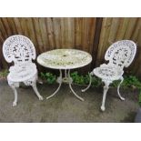 A white painted cast iron table and two matching chairs.