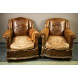 A pair of early 20th century tooled leather armchairs, the backs enriched with a tooled motif to the