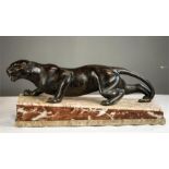 A 19th century bronze crouching panther, raised on a marble base, 52cm by 18cm by 22½cm.
