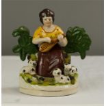 A reproduction Staffordshire style lady with mandolin and animals.