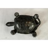 A dark patinated cast metal tortoise.