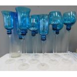 A group of large blue oversized glasses/candle holders, of varying form.