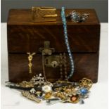 An oak box containing costume jewellery brooches, pendants, bracelets.