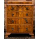 A walnut veneered chest of four drawers.