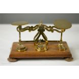 A 19th century set of brass scales, together with weights, raised on an oak base.