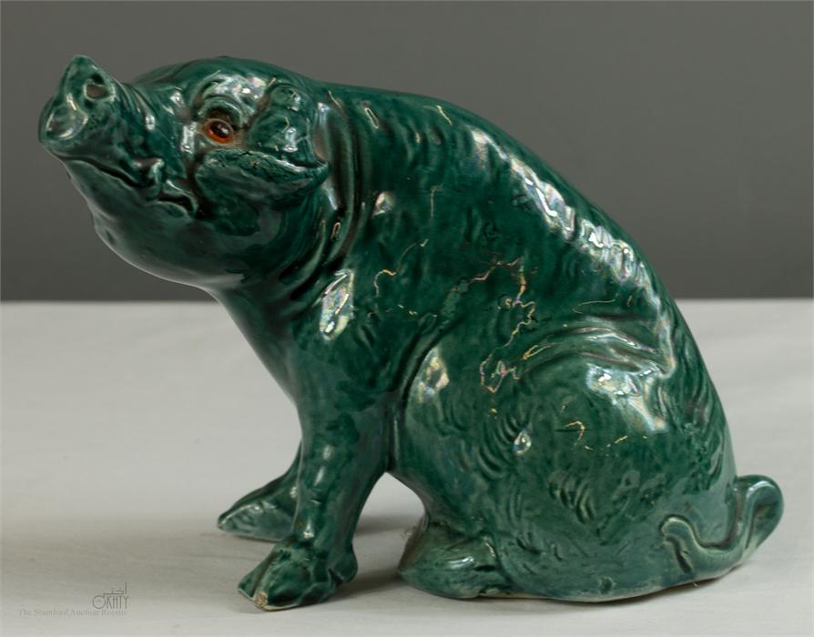 A majolica style green stoneglazed pig with glass eyes.