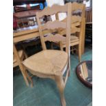 A set of ten beech ladder back kitchen chairs, with rush seats.