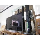 A flatscreen Samsung TV, together wtih speakers, DVD and TV box.