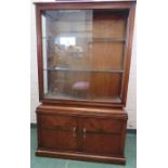 A 1950s glass display cabinet with sliding glass panel doors and two glass interior shelves, the