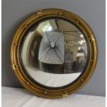A Regency style porthole mirror, with ebonised inner border and convex mirror.