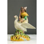 A Staffordshire figure of Mother Goose, the witch seated on the bird's back and holding a