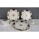 A Royal Worcester Butterflies pattern pill pot and chamberstick, and three Wedgwood plates.