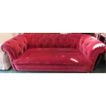 A Chesterfield type settee, upholstered in red velvet.