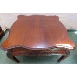A mahogany coffee table with carved decoration to the short cabriole legs.