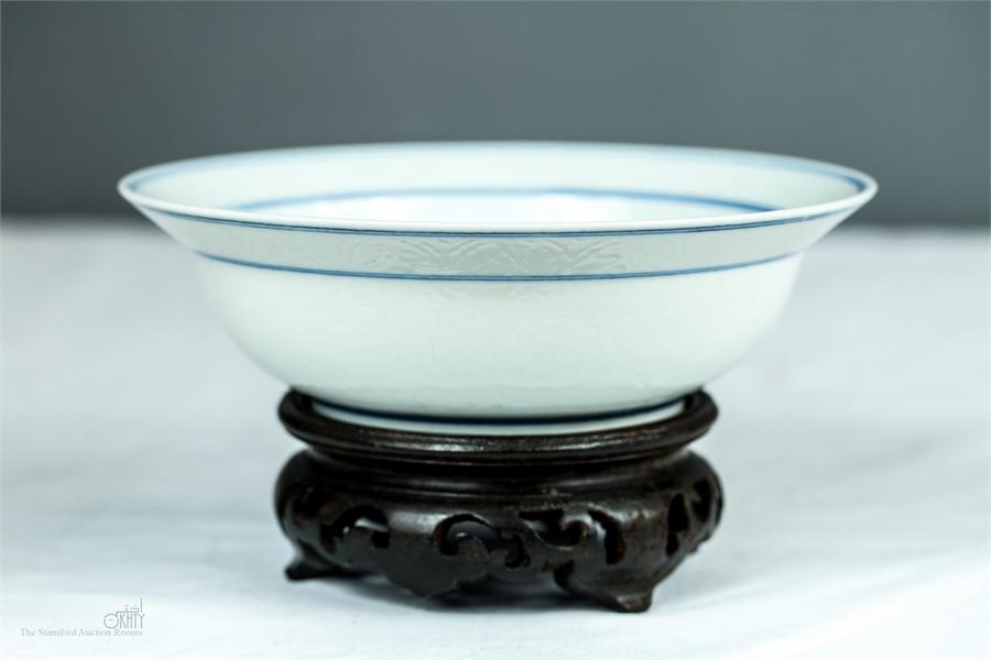 A 19th century Chinese blue and white bowl on carved wooden stand, with calligraphy to the base. - Image 2 of 3