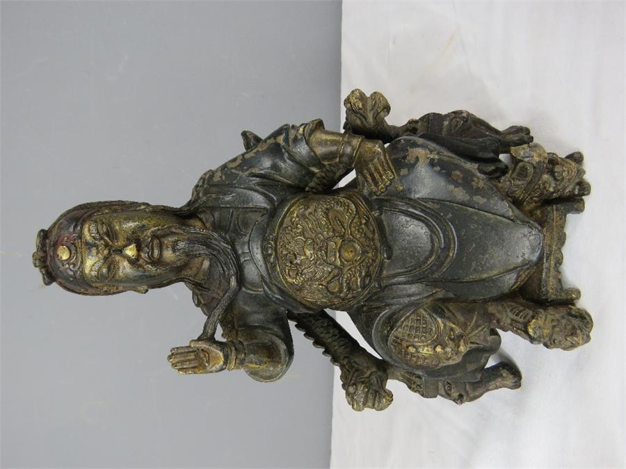 A Chinese bronzed figure of a seated man, bearing residual gilding.