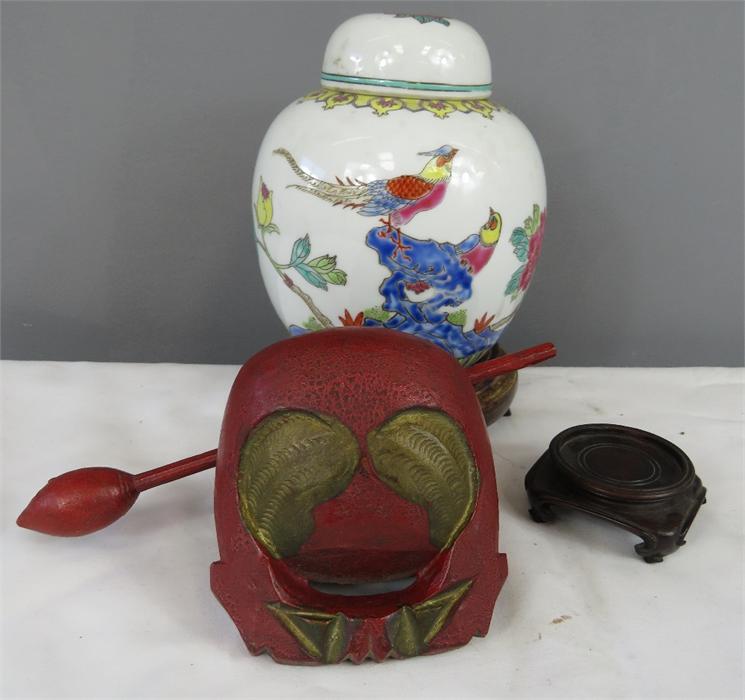 A Chinese ginger jar and cover raised on a carved stand, together with a further stand, and a